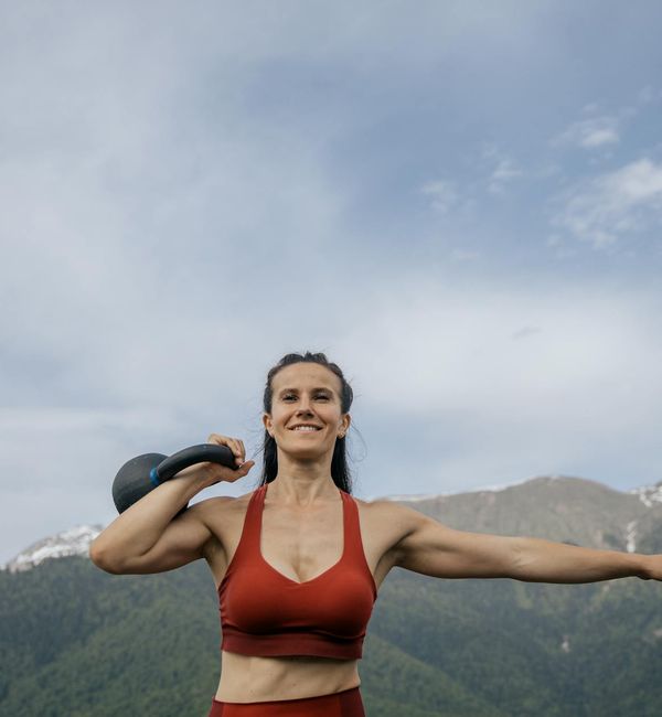 Woman feeling joyful and energetic outdoors with arms outstretched.